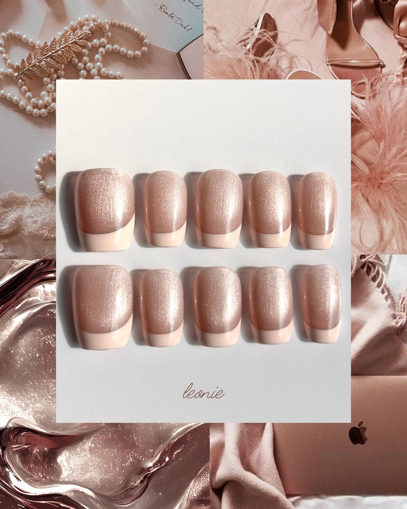 Set of rose gold press-on nails on a white card with 'leonie' branding, surrounded by decorative elements.
