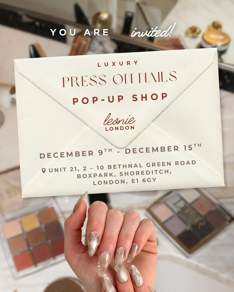 Invitation card for a luxury press-on nails pop-up shop in London, with a hand showing off nails.